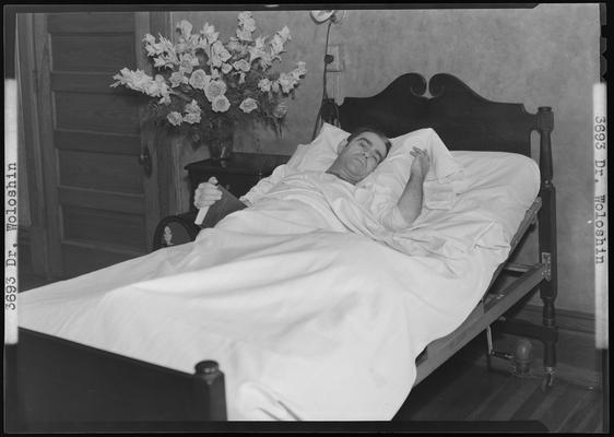 Ill patient laying in bed holding Bible