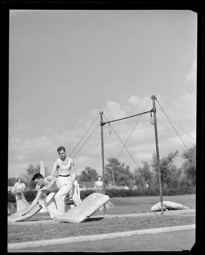 University of Kentucky May Day; acrobats performing high bars on football field