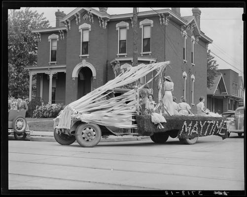 University of Kentucky May Day: float in parade, women standing on truck holding up signs saying 