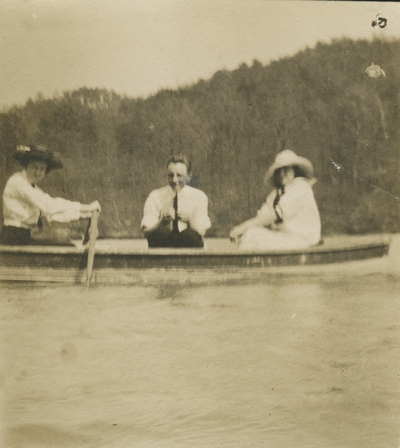 2 women and a man sitting in a boat out in the water