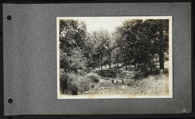 Creek with stone and wooden fence across