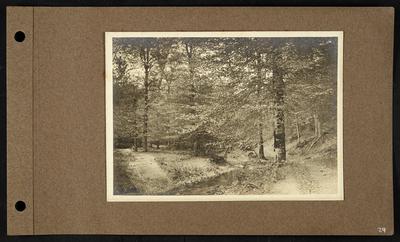 Small creek with roadway leading out of it, walkway along right bank