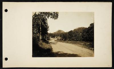 Dirt road forking in distance, possibly a rail road crossing in distance