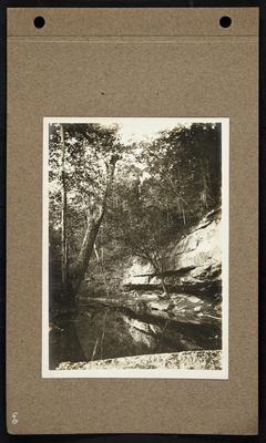 Creek reflecting small bluffs rising above it