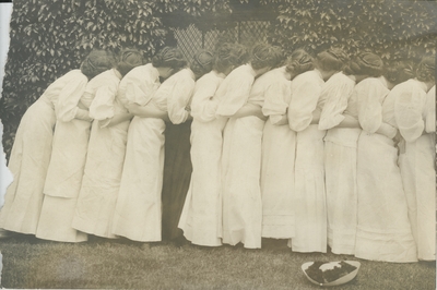 Group portrait of women, leaning on each other in a row (a back view)