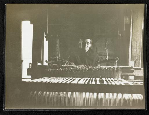 Female, unidentified, sitting at a loom