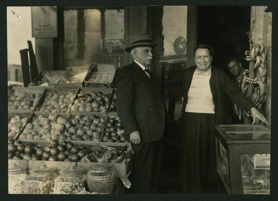 Dr. A. E. Winship visits Mrs. Tony Varisco in her grocery store and congratulates her on having learned to write and keep her store accounts