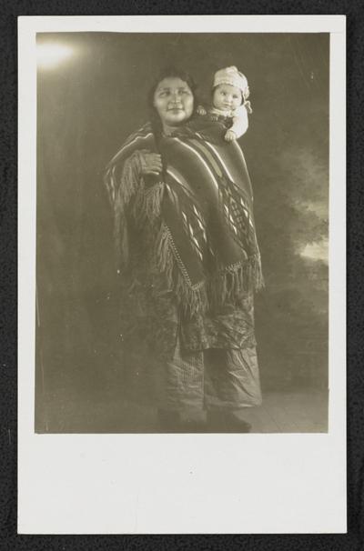 Unidentified woman holding a baby on her back