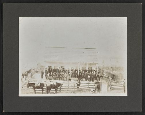 Large, unidentified group, standing in front of a building