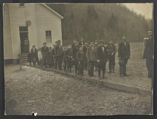 Students standing in front of school house