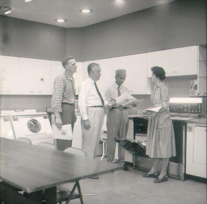 Groups; Unidentified; A group of people looking over the manual to a new stove