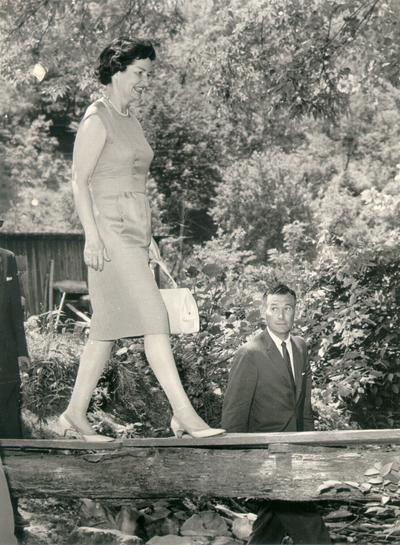 Johnson, Lyndon B. and Ladybird; The First Lady walking across a wooden plank