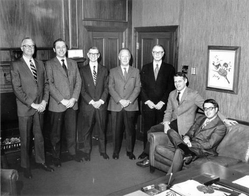 Groups; Unidentified; Seven business associates gathered inside their superior's office