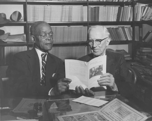 Gillis, Ezra L, death 1958, Registrar of University 1913-1937, Special Work 1937-1954, Instructor Normal Department 1907-1910, Began Bureau of Source Materials in Higher Education 1937-1958, pictured (right) with Allie Washington, African-American janitor of Lexington City Hall, discussing Lexington schools and education, featured in Lexington Herald or Leader, October 25, 1954