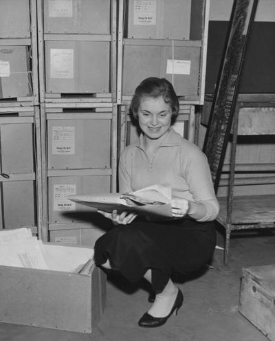 Hughes, Delmar, a member of the University of Kentucky library staff, going through some of the papers that were included in the Barkley collection now on deposit at the University of Kentucky's Margaret I. King Library, From Public Relations Department