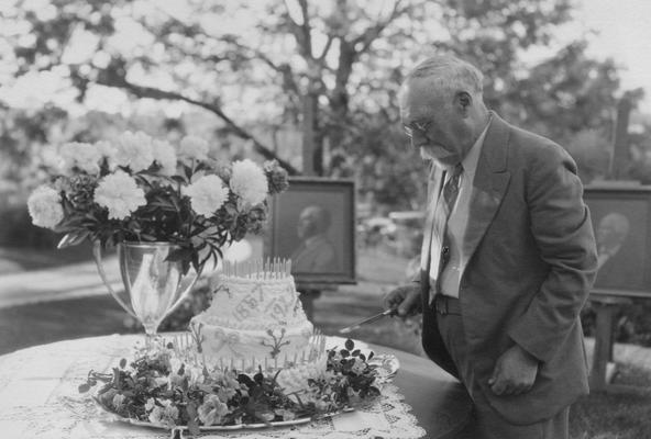 Peter, Alfred Meredith, birth 1857, death 1953, Chemist-Experiment Station 1880-1934, Emeritus Professor of Soil Technology, pictured at his retirement party about to cut the cake, the portraits of Dr. Peter and his father are in the background