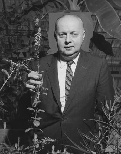 Riley, Herbert, Distinguished Professor and Head of Botany, will grow a number of South African's plants in the department's greenhouse for use in research he will conduct on these plants, Dr. Riley shown with one of the plants, Coleus penther, a member of the mint family, was awarded a National Science Foundation grant for the study, from the Public Relations Department