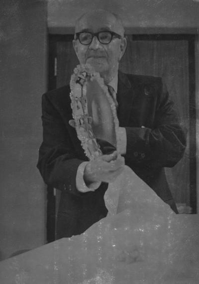 Sterret, James Reid, Assistant Professor of English, Assistant Professor for Speech, and retired president to Kentucky Inter-Collegiate Oratorical Association, is pictured displaying a silver tray he received Saturday upon his retirement as president of the KIOA, he is a native of Middlesboro and graduated high school from Lebanon in 1916, he received an AB degree from Centre College and MA and PhD degrees from the University of Wisconsin, before joining the University of Kentucky facutly he taught at Centre College for eleven years and then Western Kentucky State College for another eleven years