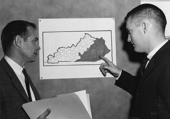 Christian, Virgil, Professor, Economics, pictured with Robert Baird, Research Assistant, Bureau of Business Research, Public Relations Department photograph, featured in Louisville Courier - Journal, December 14, 1964