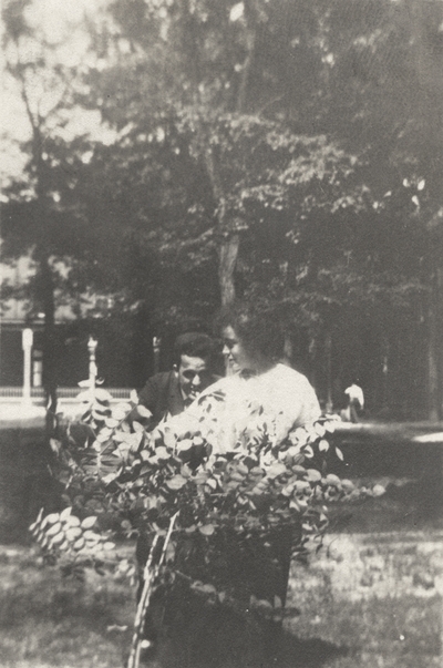 An image of Margaret Ingels and a man (possibly her older brother) standing behind a small bush