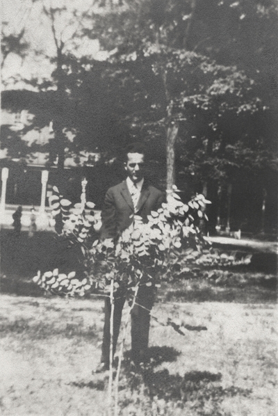 An image of a man (possibly her older brother) standing behind a small bush. This image was found pasted on the front of page 100 of 
