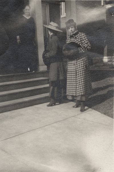 An image of a woman posing in front of a building and a man and woman talking on the left side of the print. This image was found pasted on the front of page 100 of 