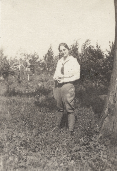 A portrait of a woman standing in a field. This image was found pasted on the front of page 108 of 