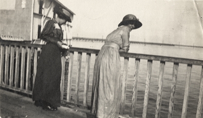 An image of two women looking over a pier. This image was found in the 