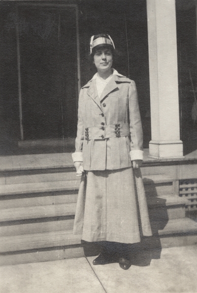 A portrait of Margaret Ingels standing in front of the steps of a house. This print was found pasted to the front of page 102 of 