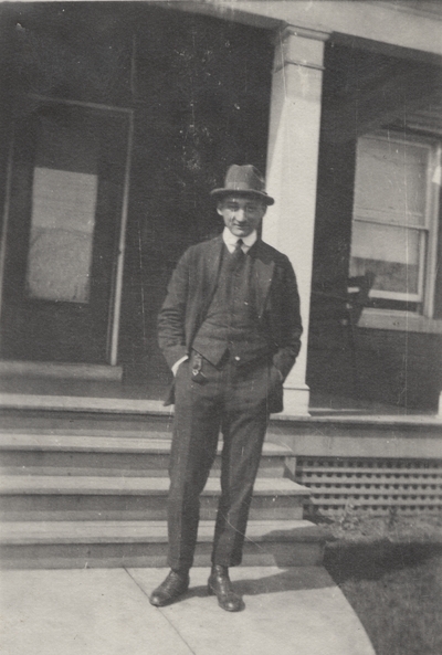 A portrait of Charles Christopher Schrader standing in front of the steps of a house. This print was found pasted to the back of page 102 of 