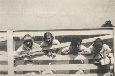 An image of four young ladies with their heads through a fence. Margaret Ingels is the second girl from the right. This image was found pasted on the front of page 100 of 