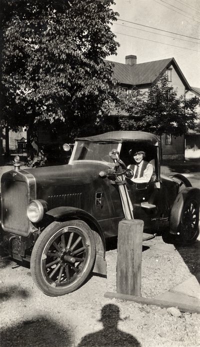 A portrait of Helen Cochran sitting in of a Ford Model A, which they called 