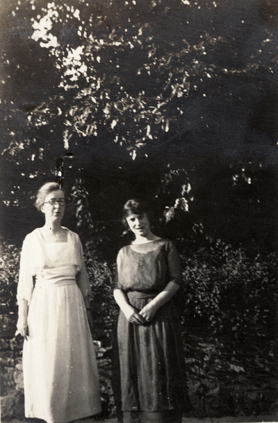 A portrait of two unidentified women standing across from a Y. W. C. A. (Young Women's Christian Association) residence by De Luxe Studio, Hot Springs, Arkansas. This print was found pasted to the front of page 109 of 