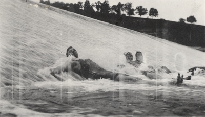 An image of three persons laying in a waterfall. This print was found pasted to the front of page 113 of 