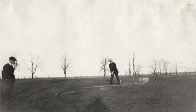 An image of two unidentified men golfing on a golf course. This print was found pasted to the back of page 114 of 