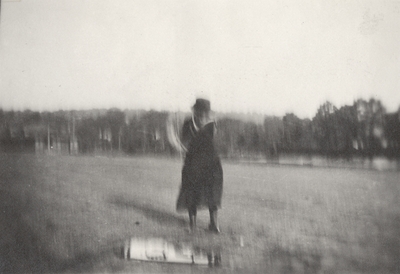 A portrait of Margaret Ingels swinging a golf club. This print was found pasted to the back of page 107 of 