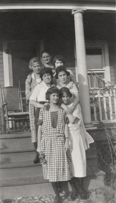 A group portrait of unidentified women standing on the steps leading to a porch. This print was printed by the Elizabeth Novelty Co. 923 Elizabeth, N. J. This print was found among the 