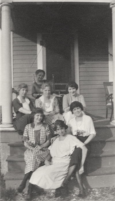 A group portrait of unidentified women sitting on the steps leading to a porch. This print was printed by the Elizabeth Novelty Co. 923 Elizabeth, N. J. This print was found among the 