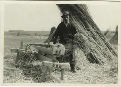 Unknown African American male with a hand brake in a field of hemp stalk stacks at at a Castleton Farm, Lexington, Kentucky; used as illustration facing page 35 in Coleman's 