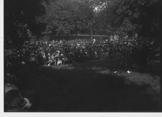 An audience watches an outdoors performance