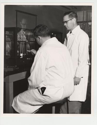 Dr. J. William Miles and Milton H. Nichols in the Pharmacy laboratory