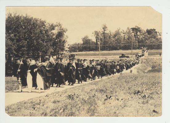 As part of the 1917 commencement, a procession with flags crosses Limestone Street