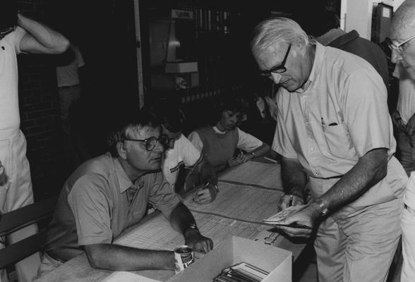 Jay Brumfield (standing) is showing Bob Whitaker something at an unknown event