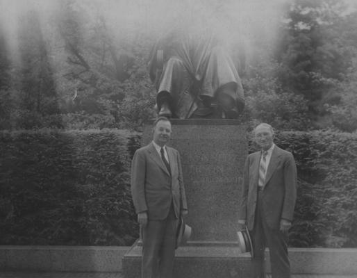 University President Herman Donovan (left) standing next to a former student of the class of 1876, J. E. Taylor (right) in front of the statue of President James K. Patterson