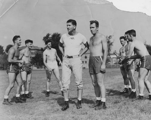 Albert D. (Ab) Kirwan as coach of the UK football team, talking with captain Joe Shepherd, with other players