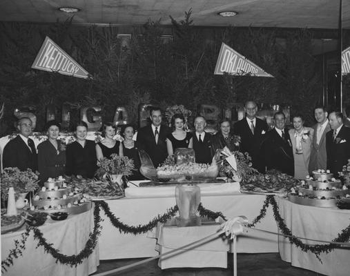 Celebration dinner after UK victory over Oklahoma in the Sugar Bowl, New Year's Day, 1951; pictured from right, Charles Grenrod, Ab Kirwan, Betty Kirwan, Governor A. B. Chandler, Athletics Director Bernie Shively, Mrs. Chandler, UK President Herman Donovan; others are unidentified; photographer:  Leon Price Picture Service