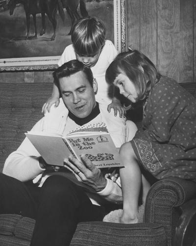 Former UK basketball player and Athletics Director Cliff Hagan pictured reading to his children; photo taken when Hagan was player/coach of the Dallas Chapparals of the now-defunct American Basketball Association; Dallas Morning News staff photo, Jo Ball, photographer