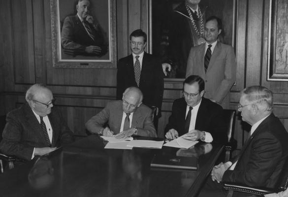 University President Charles T. Wethington, former Kentucky Governor Ed Breathitt (far left), Vice President Ben Carr (standing, right) and other members of the University of Kentucky Board of Trustees meet in the Administration Building boardroom
