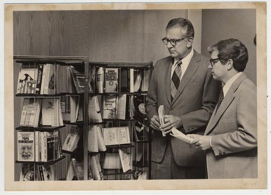 University of Kentucky President Otis A. Singletary (left) and Paul A. Willis, Director of UK Libraries, look at a paperback collection in the Margaret I. King Library of popular works, best sellers, and classics; Dr. Singletary originated the idea for the collection and his office provides funds for the books