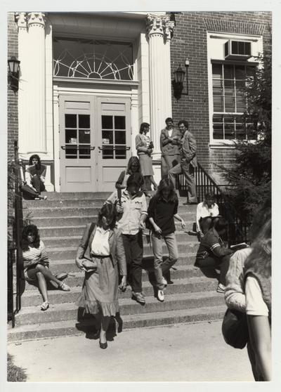Students and staff on the steps of McVey Hall; Mike Lach stands top right; Submitted for use the the 1983 / 1984 annual Report